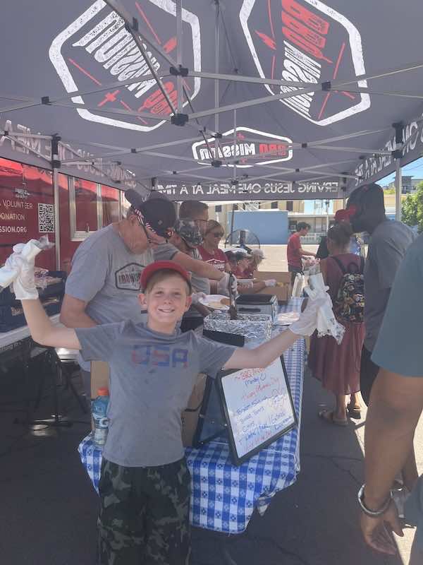 young boy volunteering at table